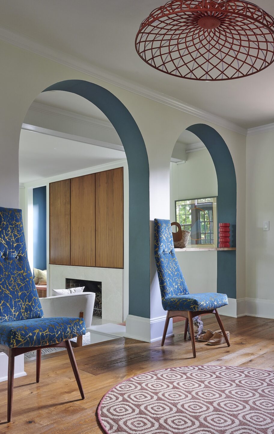 mid-century-modern-foyer-with-arched-architecture-and-bold-statement-chairs